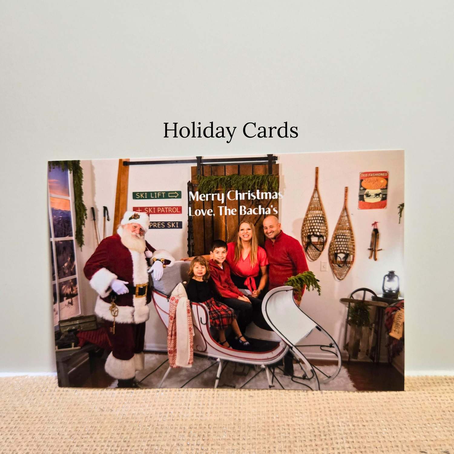 4x6 or 5x7 Holiday card prints with a family and Santa Claus on a couch, featuring the text 'Merry Christmas Love, The Bacha's'. Fast shipping and affordable.